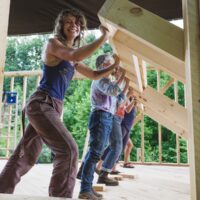 People participate in Wall raising: building yourself is one way to save on a tiny house