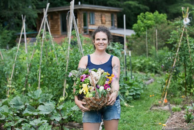 woman holding a basket of vegetables and flowers