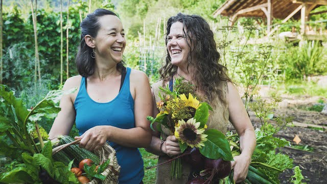 Natalie and Chloe in the garden with flowers and vegetables