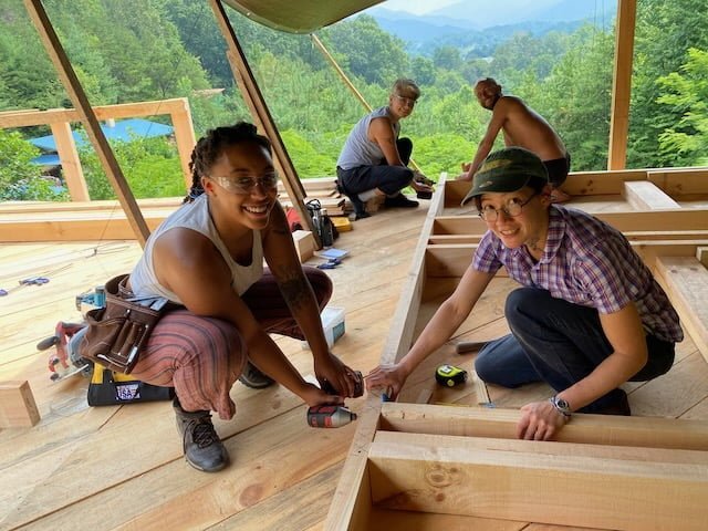 group of people building a tiny house together