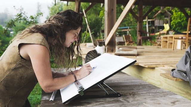 Natalie working on a drafting table designing a tiny house