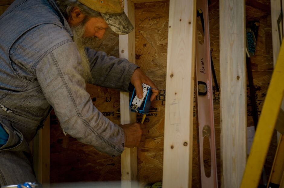 man installing an outlet in a tiny house