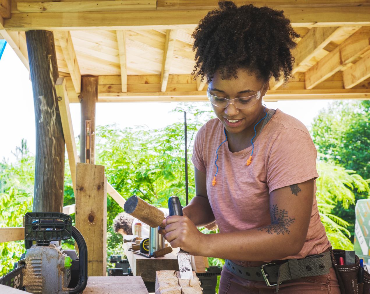 woman using a chisel to build a tiny house