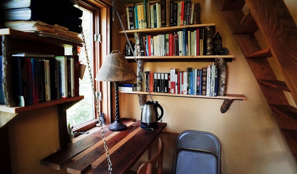 A desk in a tiny house under the stairs