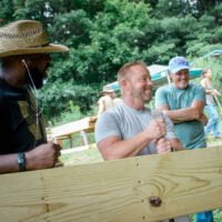 Men laugh together during advanced all genders carpentry class