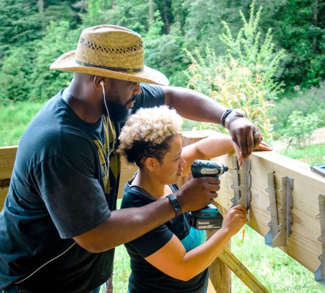 Male and female student work together during all genders carpentry class