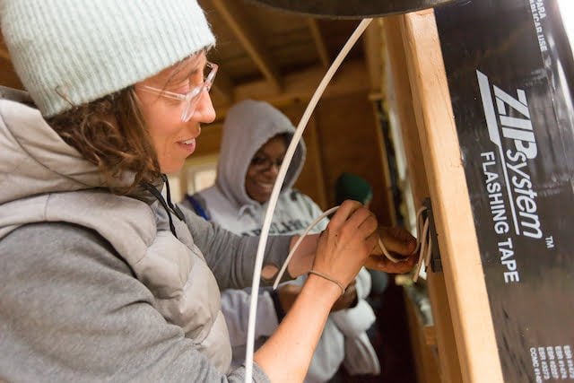 Two students work with electrical during building apprenticeship.