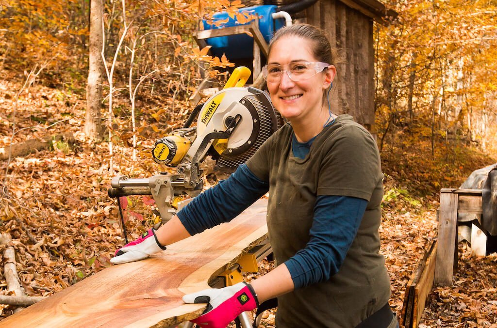 woman holding a board working on siding for a tiny house