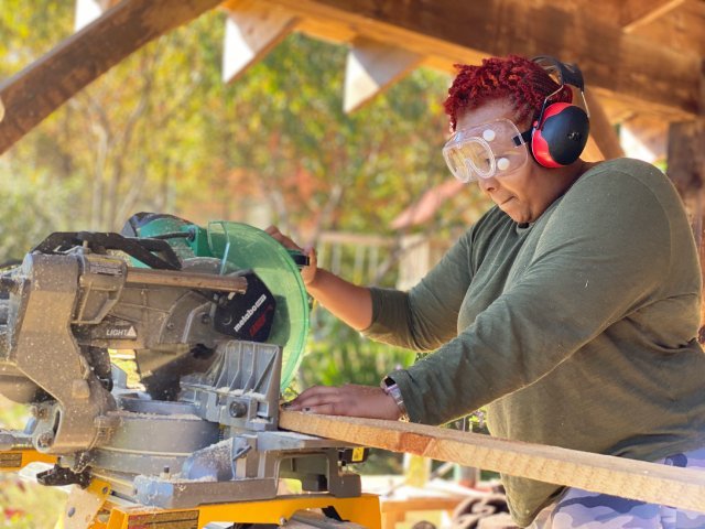 all genders carpentry student using chop saw