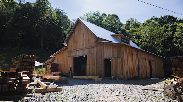 Ivy Creek Timber Frames Wild Abundance Class location. Timber frame barn sits amongst trees.