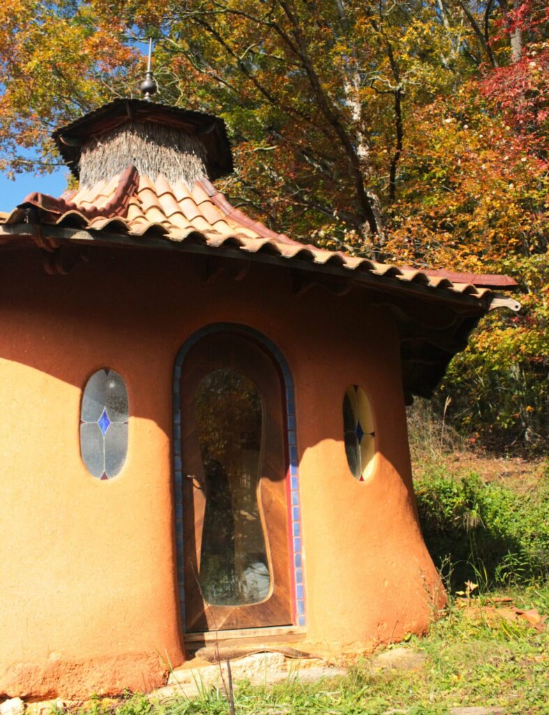 Cute cob home made of sustainable building materials in a round hut shape