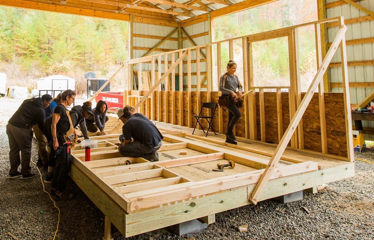 Students work on framing the 2nd wall for a Tiny House during the 10 day hands-on Tiny Home building workshop at Wild Abundance