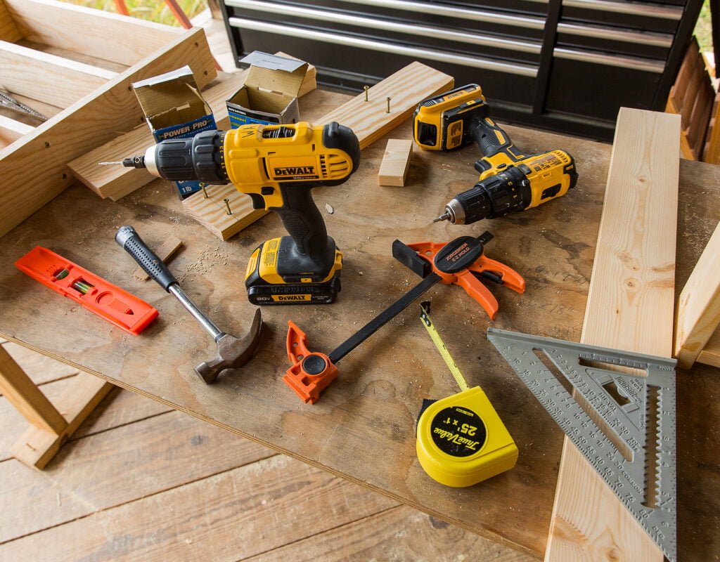 An array of tools lay on a workshop table at the outdoor carpentry classroom