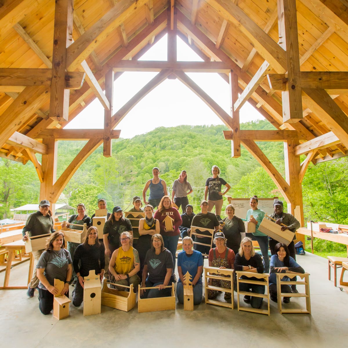 2025-85 Women pose for a group picture with their personal projects on the last day of a Basic Carpentry 4 day workshop at Wild Abundance in North Carolina
