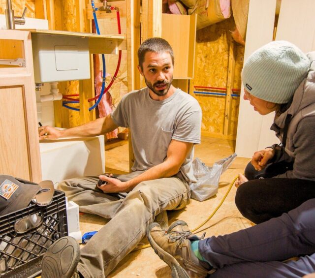 Austin instructs students on how plumbing installation practices in a project building at Wild Abundance's 4 month carpentry program