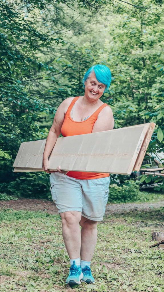 Woman carrying lumber for her carpentry project at Wild Abundance's all genders intensive woodworking class for beginners