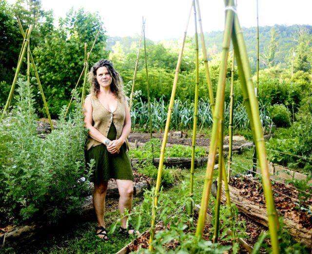 Natalie Bogwalker stands in her home garden where she teaches students permaculture skills and how to grow organic food