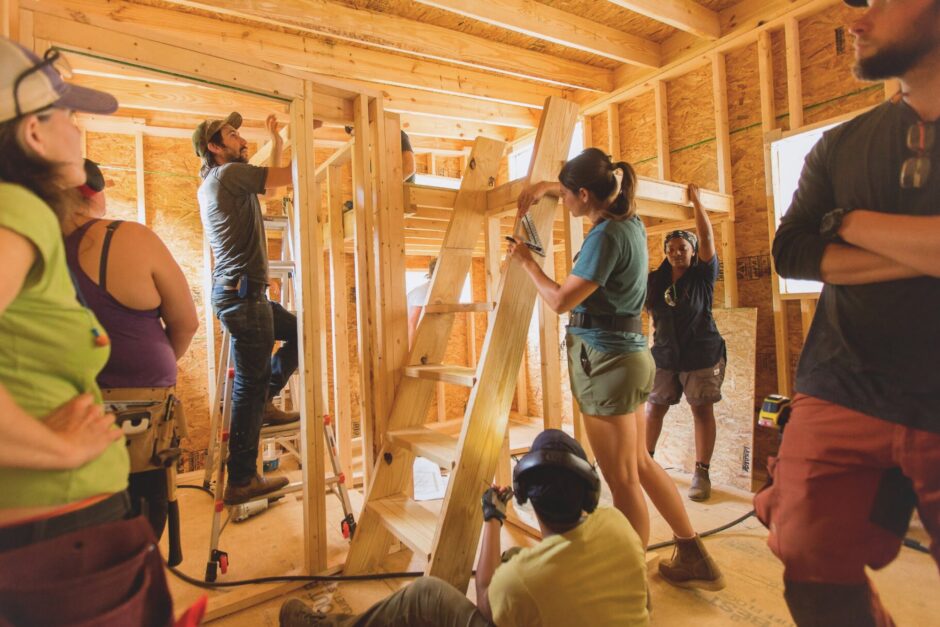 Instructor Pete gives students guidance as they work on the interior wall framing and stairs to a loft in a tiny house building workshop