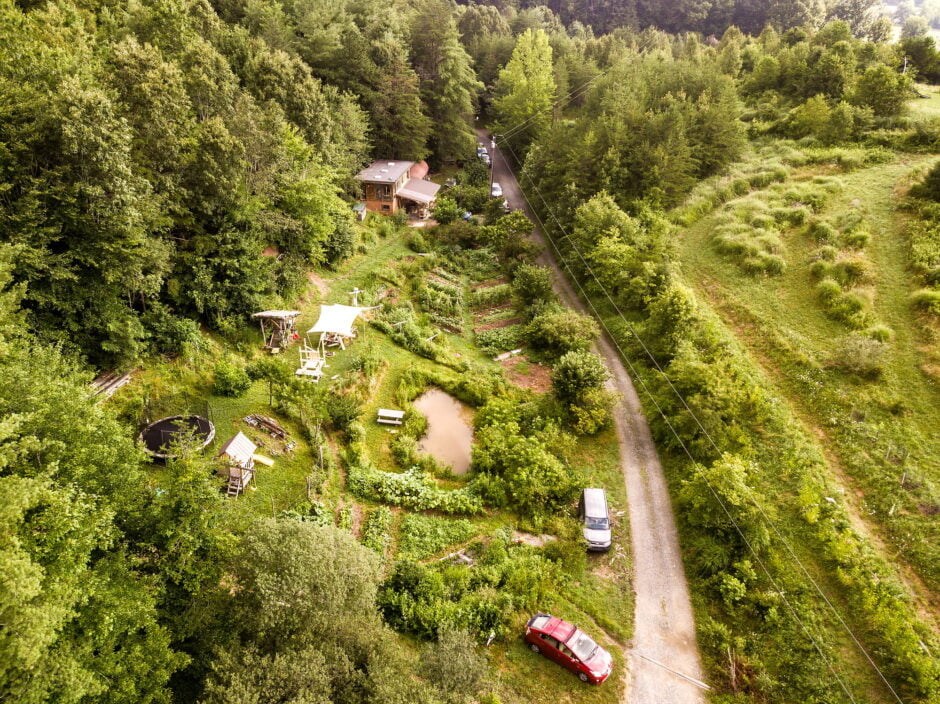 Wild Abundance's original campus as shot from a drone looking down on the verdant permaculture landscape design