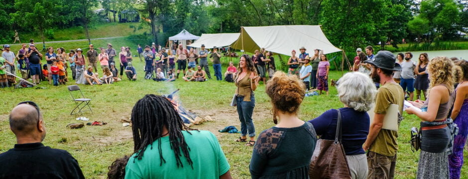 Natalie, the founder of Wild Abundance, seen speaking to a crowd of diverse people during the annual Firefly Gathering