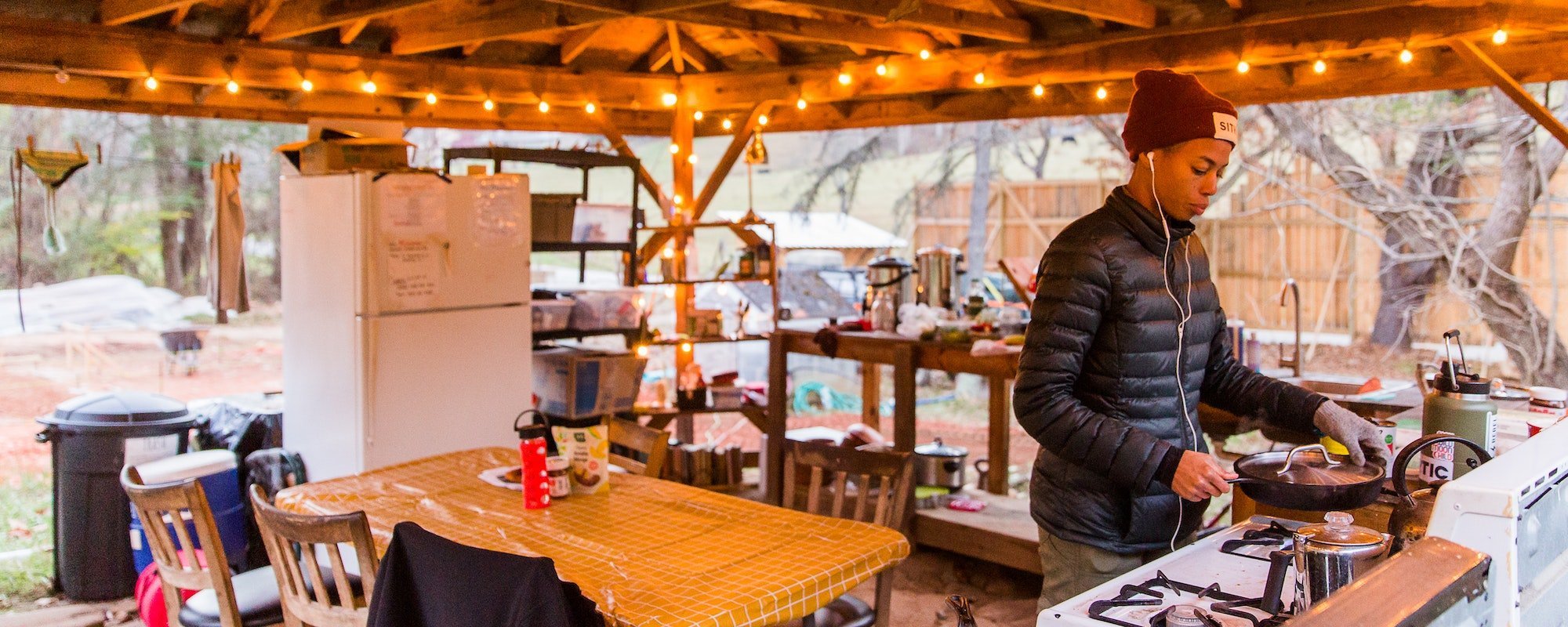 A student cooks herself a meal at the outdoor kitchen of the Paint Fork Campus of Wild Abundance