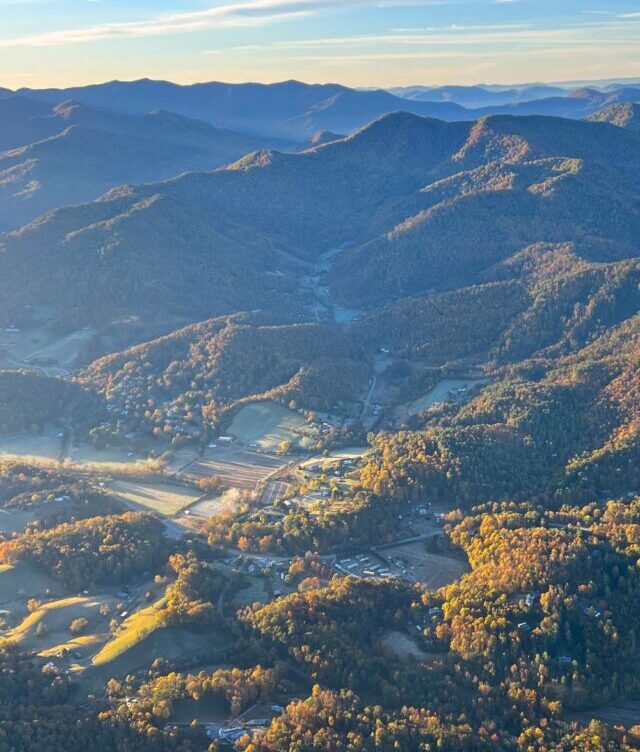 An aerial view of the mountains and valleys surrounding the WIld Abundance campuses just north of Asheville, NC.