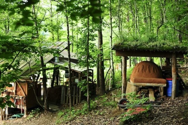 A view of the outdoor kitchen and covered cob oven at the original Sanford Way Wild Abundance campus for herbalism and rewilding classes