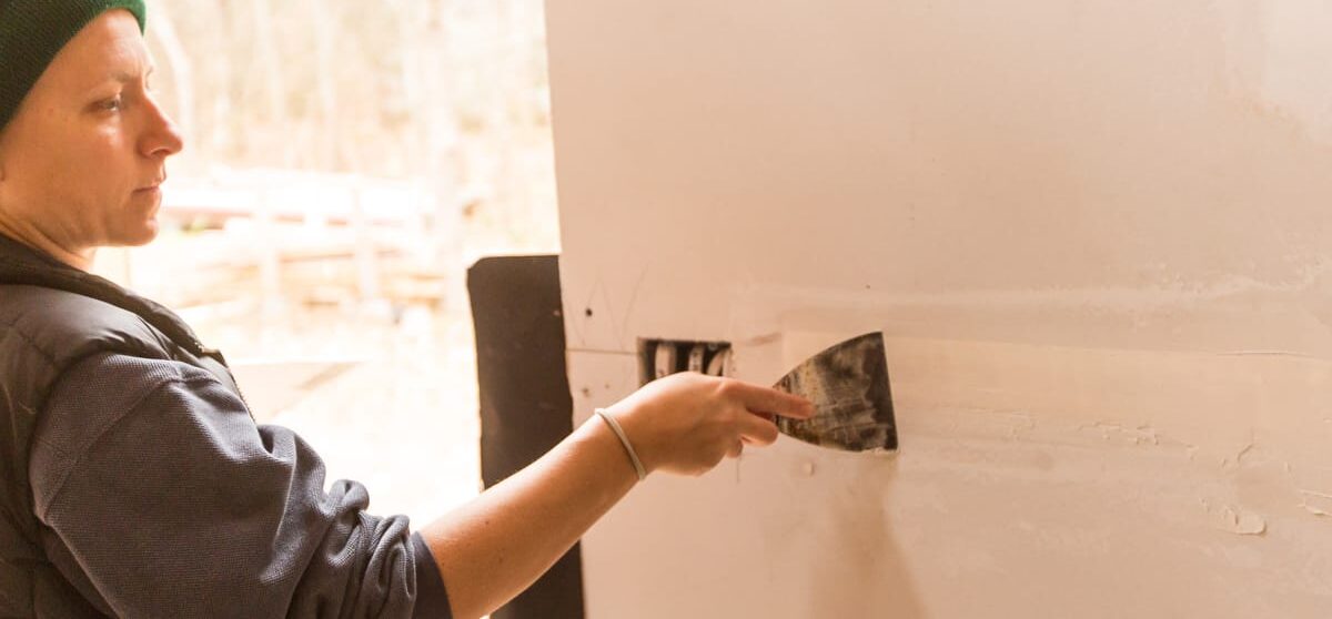 10-Handy Homeowner Bootcamp 2025 a student patches drywall in the Handy Homeowner bootcamp workshop at Wild Abundnace