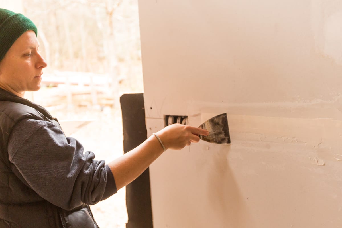 10-Handy Homeowner Bootcamp 2025 a student patches drywall in the Handy Homeowner bootcamp workshop at Wild Abundnace