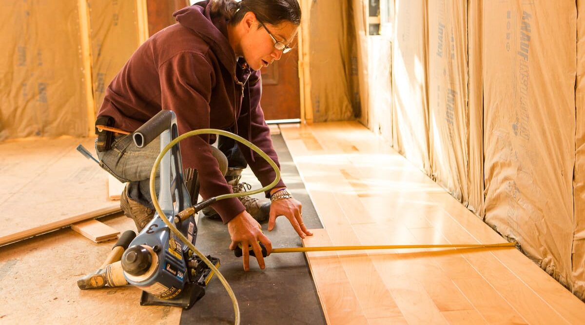 16-Handy Homeowner Bootcamp 2025 A student installs flooring at a Handy Homeowner bootcamp at Wild Abundance