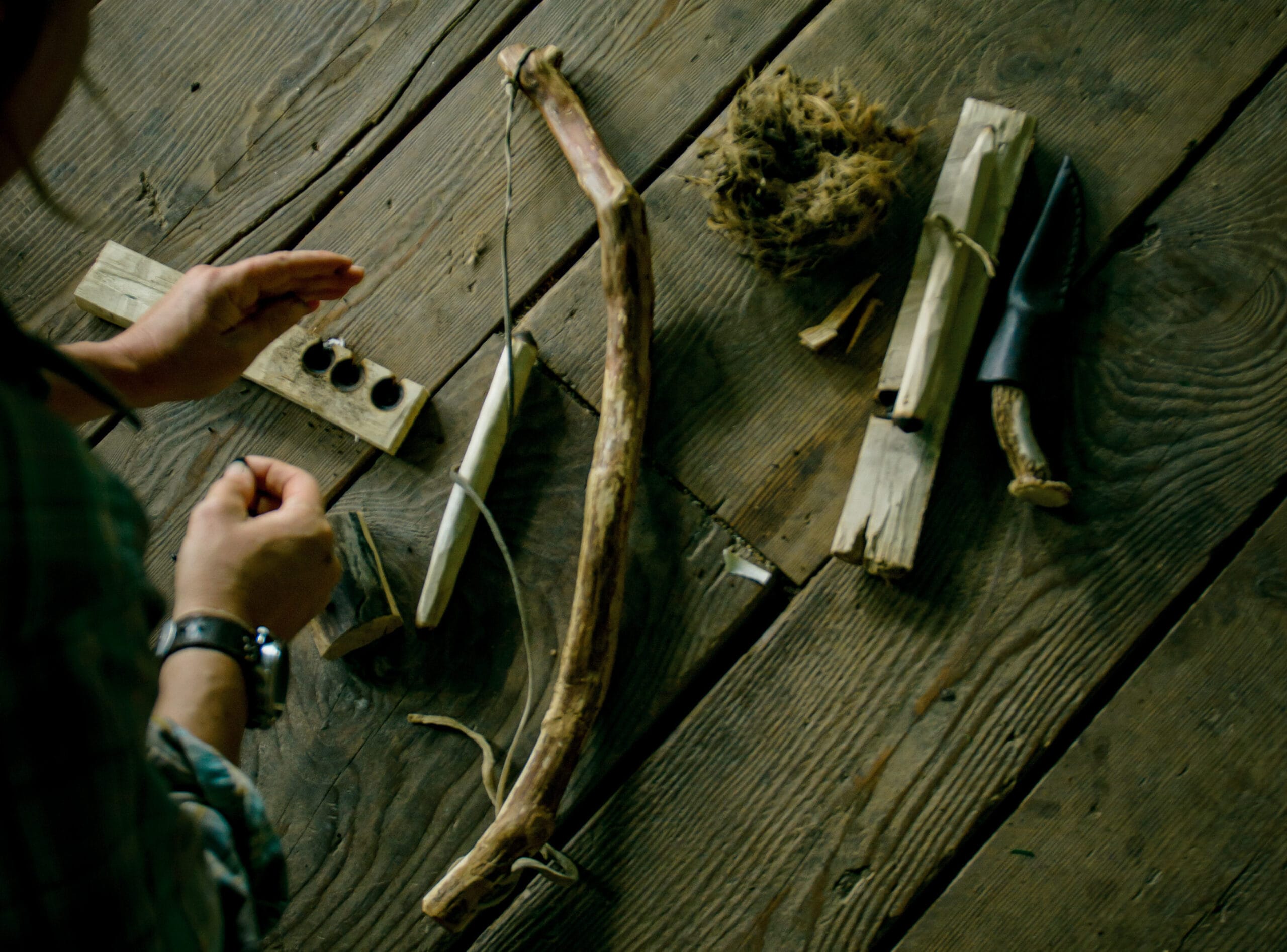 close-up of hands using a bow drill