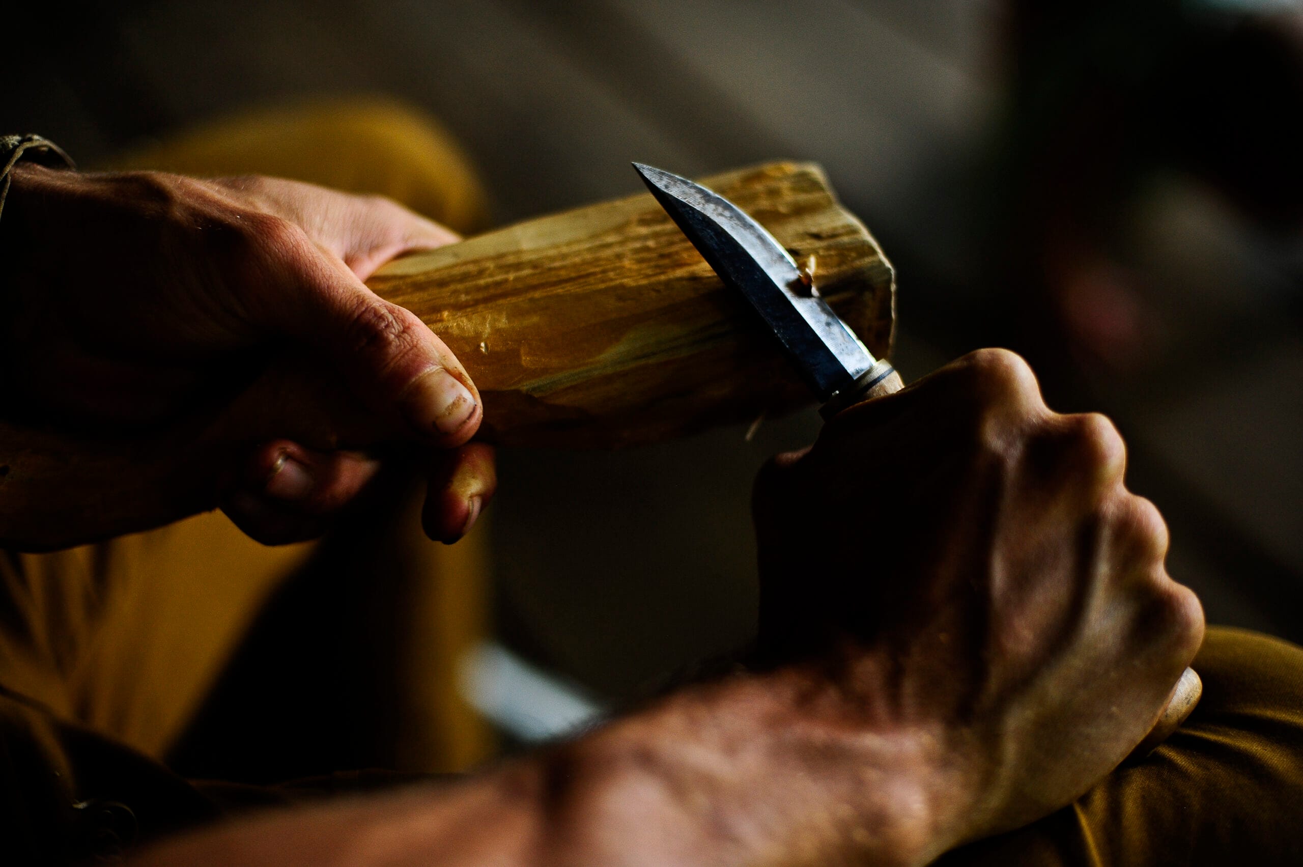 instructor demonstrating knife posture while shaping a spindle