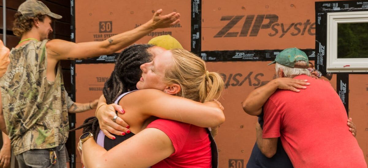 FAQ page 665 2025-1200-Current- Students hug each other goodbye after a closing circle concluding a 10 day hands-on Tiny House Building Workshop at Wild Abundance in North Carolina