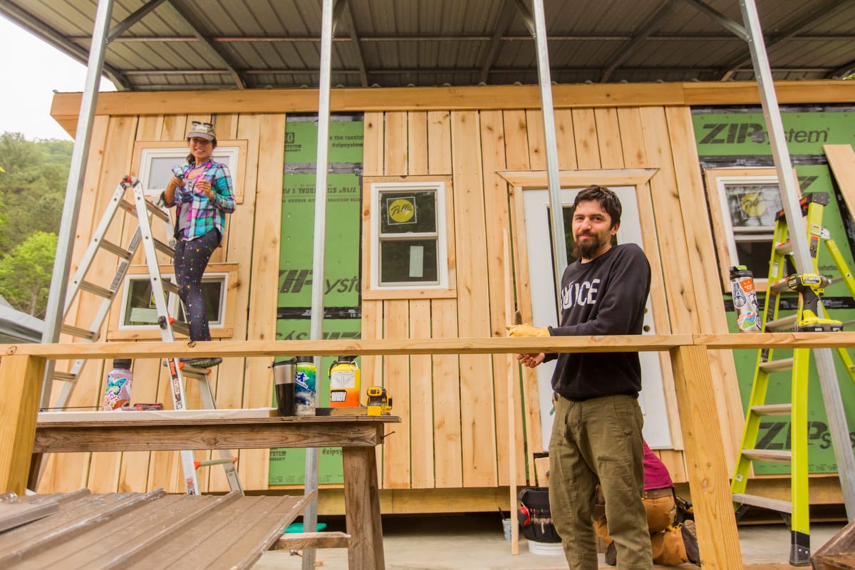 Nonprofit-1200-Current-601 Students in a 4 month Carpentry Training Program pause to smile from their work siding a Tiny House built for donation to a housing insecure victim of Hurricane Helene